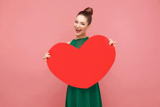 Happiness woman holding big red heart, toothy smiling
