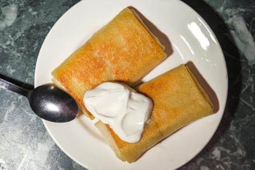 the pancakes with sour cream on a plate