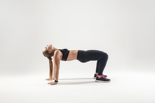 Blonde woman standing in flip-the-dog posture. Fitness concept.