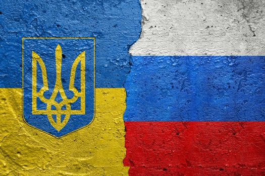 Ukraine and Russia flag- Cracked concrete wall painted with a Ukrainian flag on the left and a Russian flag on the right stock photo