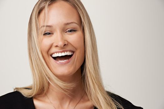 Laughter and happiness. A gorgeous young blonde woman smiling at the camera.
