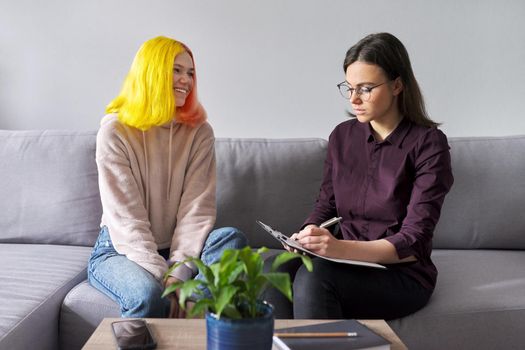 Woman psychologist working with teen girl