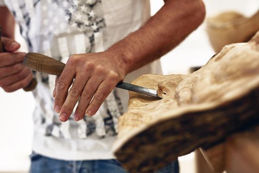Hes carving his own path to success. Cropped shot of an artist carving something out of wood.