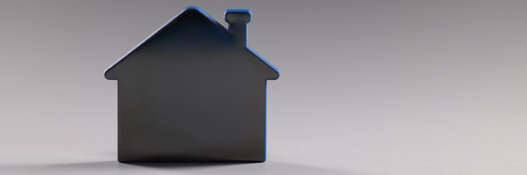 Mock up toy house standing on gray background closeup