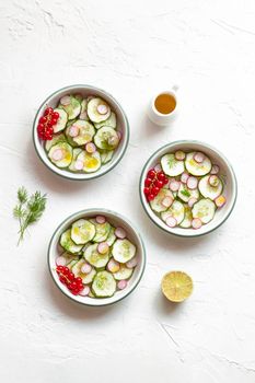 Radish and cucumber salad served in round bowls decorated with red currants