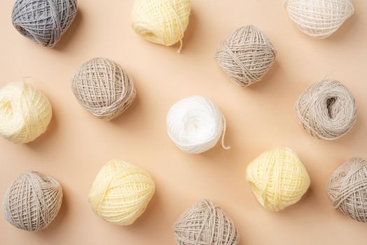 pastel and beige colored yarn wool on beige backdrop, top view flat lay