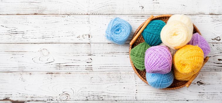 bright colorful yarn wool in a basket on wooden background