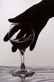 A woman's hand reaches for a glass of spilled wine. Female alcoholism