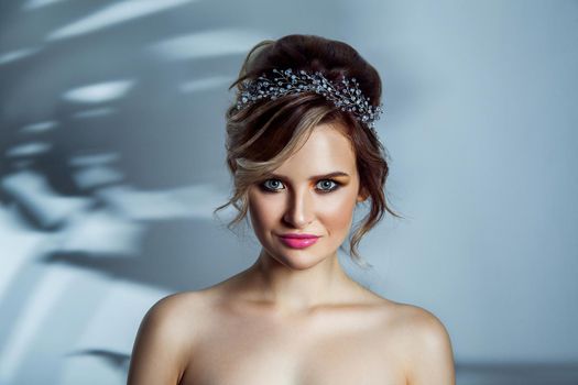 Beauty portrait of beautiful fashion model with makeup, and collected hairstyle.