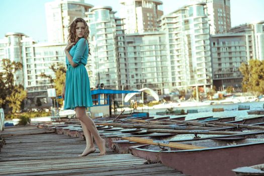 Young beautiful fashion model posing on pier.