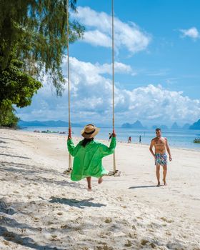 couple men and woman on the beach of the tropical Island Naka Island near Phuket Thailand
