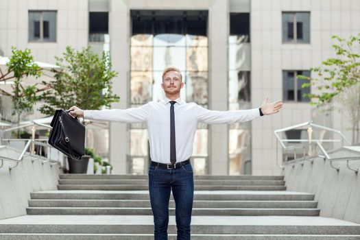 businessman keeping arms raised and expressing positivity while standing