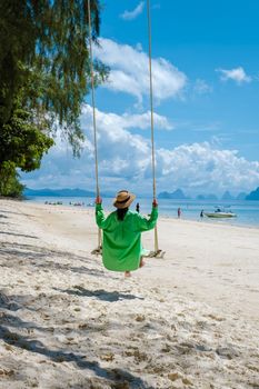 couple men and woman on the beach of the tropical Island Naka Island near Phuket Thailand