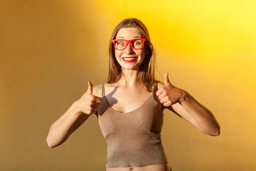 Like it! Femininity attractive girl with glasses, thumbs up, toothy smile and looking at camera.
