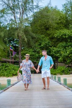 couple men and woman on a tropical isalnd with wooden pier jetty,