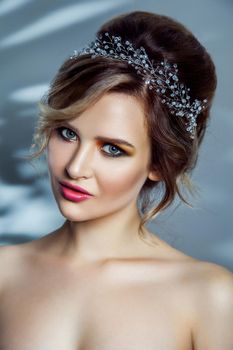 Beauty portrait of beautiful fashion model with makeup, and collected hairstyle.