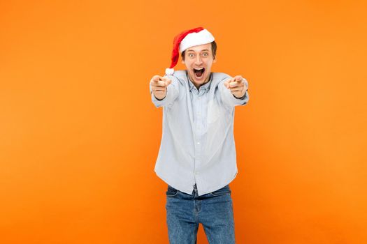 New year is coming! Attractive man pointing finger at camera, and toothy smiling.