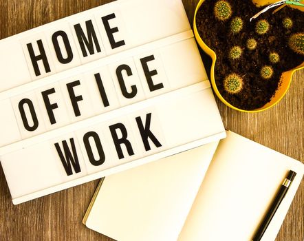lightbox with text HOME OFFICE WORK with notebook pen and cactus and TO DO list, copy space wooden table background, quarantine and isolation HOME OFFICE