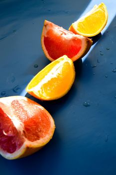 Colored Citrus fruits on a blue background. Slices of citrus and peel. Grapefruit and orange Healthy dessert for diet and slimming