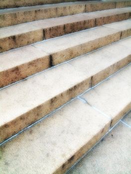 A closeup of a staircase. Details of an empty stairway outside in an urban city or town. Wide solid stairs found in commercial or big residential buildings. Light textures on stony or concrete steps