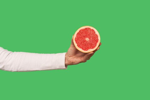 Closeup of hand holding sliced juicy grapefruit