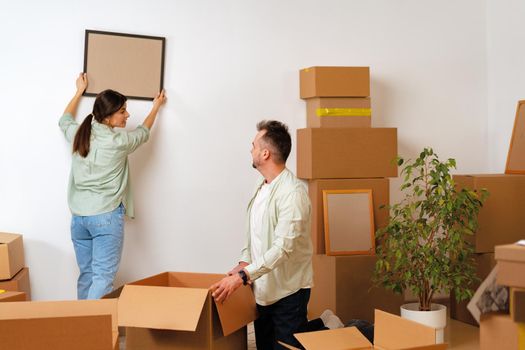 Young happy couple in room with lots of moving boxes
