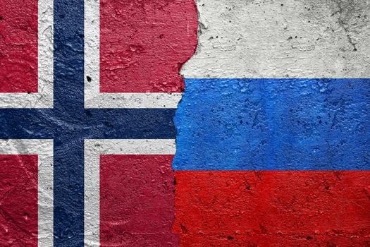 Norway and Russia - Cracked concrete wall painted with a Norwegian flag on the left and a Russian flag on the right stock photo