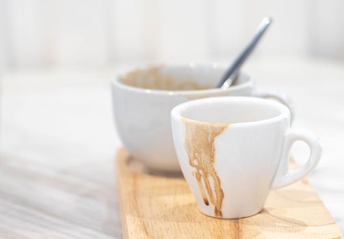 Dirty coffee white mug and Coffee mug stain on wooden plate.