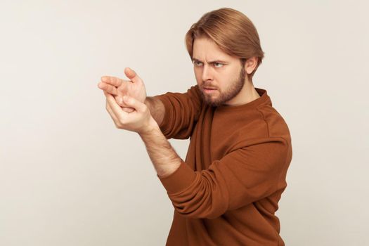 Aimed shot. Portrait of concentrated focused bearded man pointing finger gun gesture to target, threatening to kill