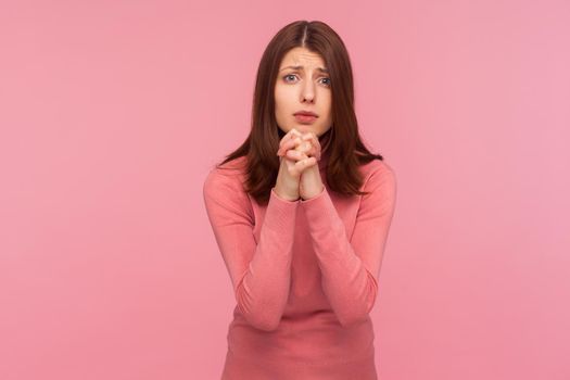 Portrait of emotional brunette young woman on pink background.