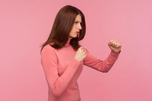 Portrait of emotional brunette young woman on pink background.