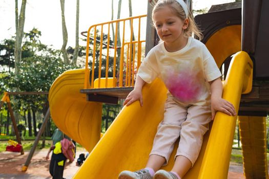 Active blonde little girl playing on a playground