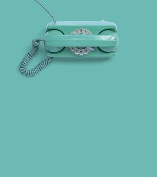 A green vintage dial telephone.