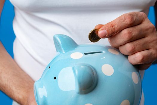 Close up of man holding piggy bank, saving money for investment