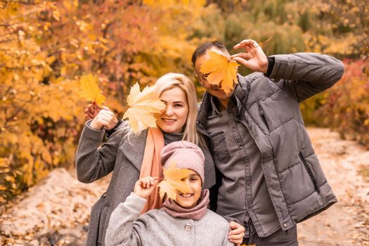 A Family of four enjoying golden leaves in autumn park