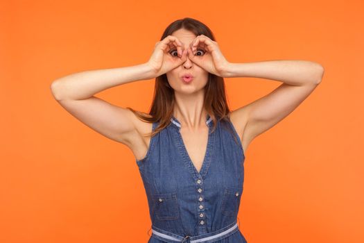 Portrait of young emotional woman on orange background.
