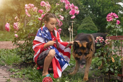 Pretty young pre-teen girl in field holding American flag. Independence Day