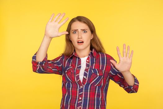 Portrait of young emotional woman on yellow background.