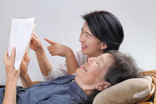 elderly woman reading fable book with daughter