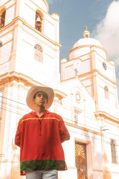 Latin teenager with classic clothes and hat from Nicaragua and the traditional dance from Latin America in front of the cathedral church