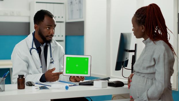 Health specialist showing horizontal greenscreen on tablet