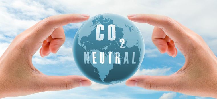Carbon neutral concept. Hand holding CO2 neutral in globe map on blue sky and white clouds background. Environment day. Carbon neutral web banner. Environment issue. Global carbon neutrality concept.