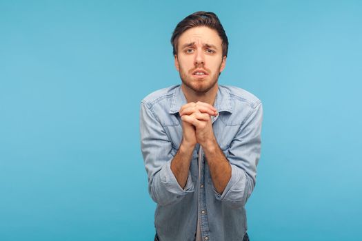 Portrait of young emotional man on blue background.