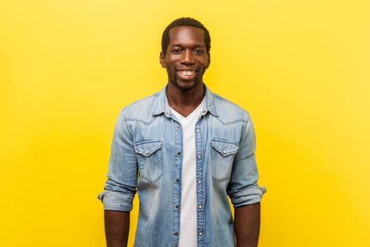 Young emotional man on yellow background.