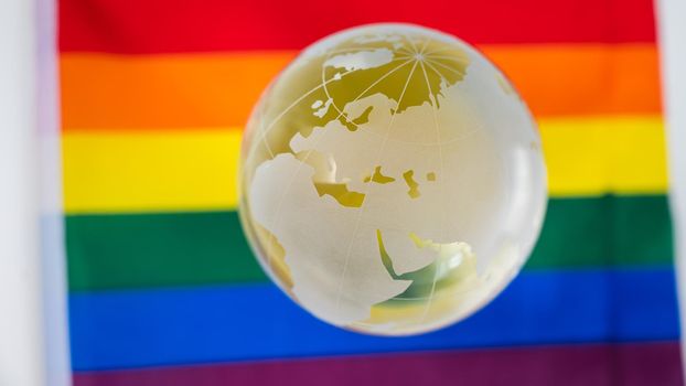Crystal globe on a rainbow flag. LGBT community.