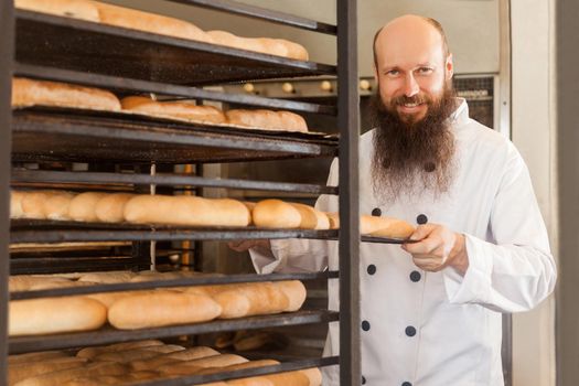 Baker man in white uniform in the bakery.