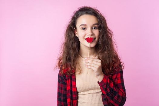 Emotional teenager girl on pink background.