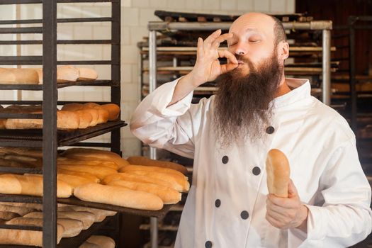 Baker man in white uniform in the bakery.
