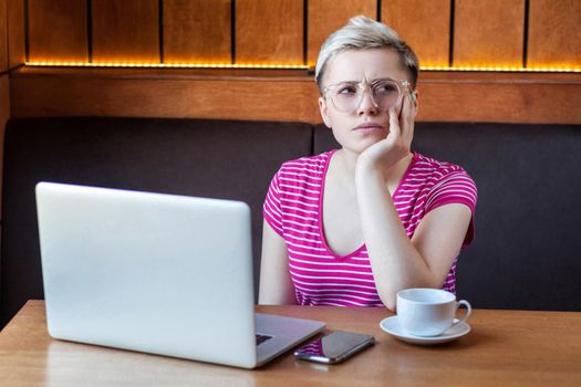 Emotional young woman sitting and working in office