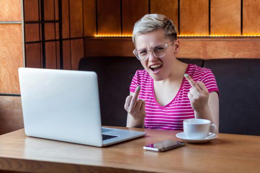 Emotional young woman sitting and working in office